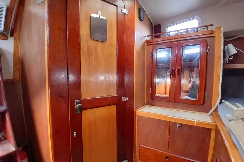 Slide: The Image of Interior of a 1982 Morgan 416 sailboat featuring wooden cabinetry and mirrored storage. - 23