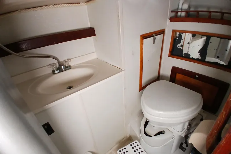 Slide: The Image of Compact bathroom in a 1982 Morgan 416 boat, featuring a sink and toilet. - 24