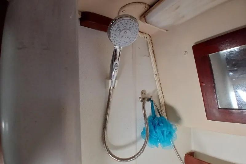 Slide: The Image of Shower area inside a 1982 Morgan 416 boat, featuring a handheld showerhead and blue bath sponge. - 25