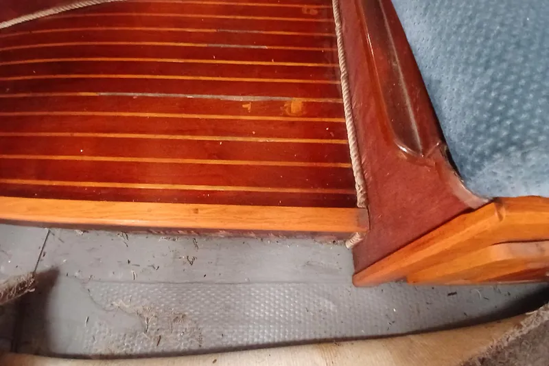 Slide: The Image of Interior of a 1982 Morgan 416 boat featuring polished wooden flooring and blue upholstery. - 28