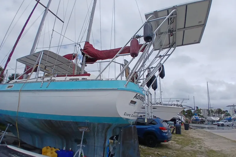 Slide: The Image of 1982 Morgan 416 sailboat on land, featuring solar panels and red sails, Cape Canaveral. - 4