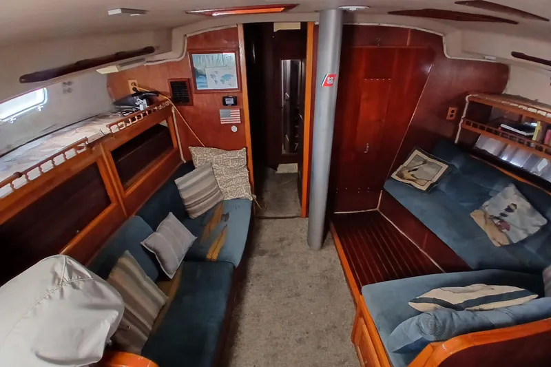 Slide: The Image of Interior of a 1982 Morgan 416 sailboat with cozy seating and wooden accents. - 8