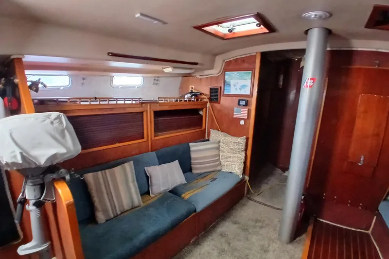 Slide: The Image of Interior of a 1982 Morgan 416 sailboat with cozy seating and wooden accents. - 9