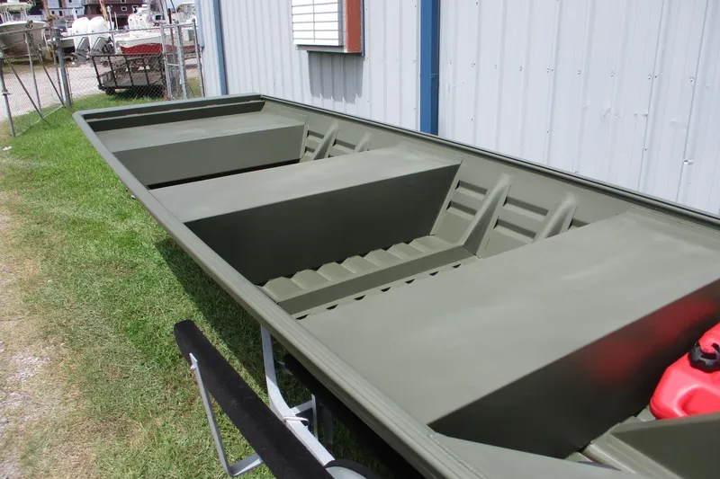 Slide: The Image of 2025 Alweld 1442 Flat Bottom boat, olive green, parked outdoors near a building. - 4