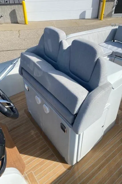 Slide: The Image of 2022 SACS Strider 900 boat with gray cushioned seating and wooden deck. - 12