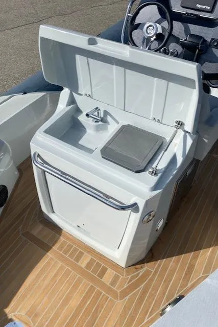 Slide: The Image of 2022 SACS Strider 900 boat interior with open storage compartment and steering console. - 8