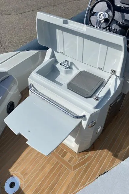 Slide: The Image of 2022 SACS Strider 900 boat interior with open storage compartments and wooden deck. - 9