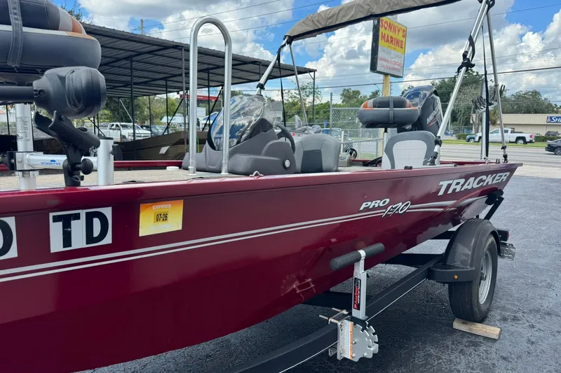Slide: The Image of 2022 Tracker Pro 170 boat in maroon, displayed at a marine dealership. - 3
