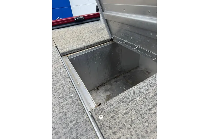 Slide: The Image of Open storage compartment on 2022 Tracker Pro 170 boat, featuring carpeted interior. - 8