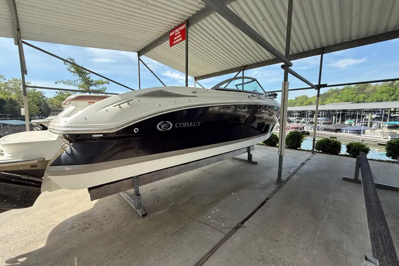 Slide: The Image of 2011 Cobalt 232 boat on a lift in a marina setting. - 13