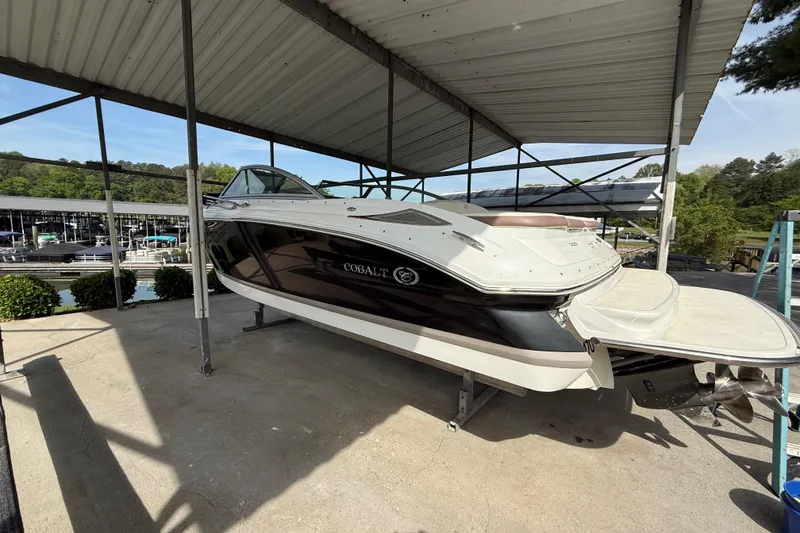 Slide: The Image of 2011 Cobalt 232 boat on a lift under a covered dock. - 16