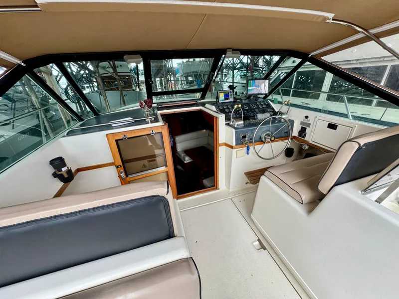 Slide: The Image of 1988 Tiara Yachts 3100 Open helm with steering wheel, gauges, and navigation equipment. - 12