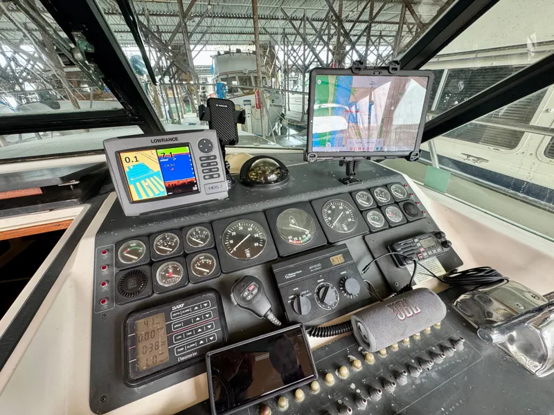 Slide: The Image of 1988 Tiara Yachts 3100 Open cockpit with steering wheel, seating, and navigation equipment. - 13