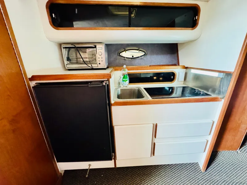 Slide: The Image of 1988 Tiara Yachts 3100 Open cabin interior with white seating and wooden table. - 17