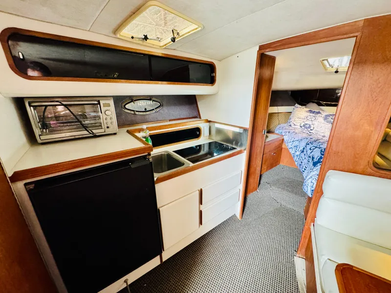 Slide: The Image of Compact kitchen area in a 1988 Tiara Yachts 3100 Open, featuring a sink and appliances. - 18