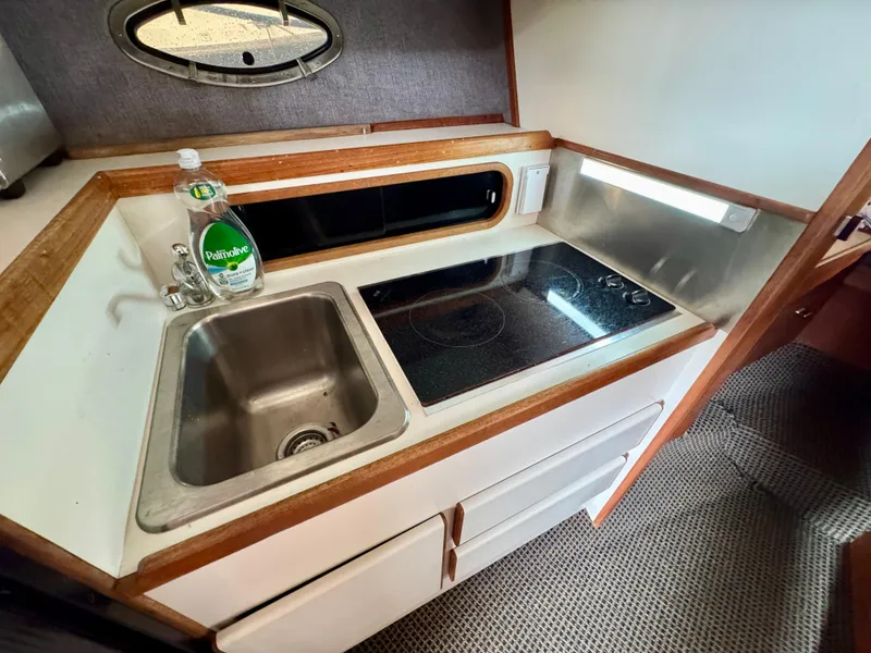 Slide: The Image of 1988 Tiara Yachts 3100 Open interior with kitchenette and cozy sleeping area. - 19