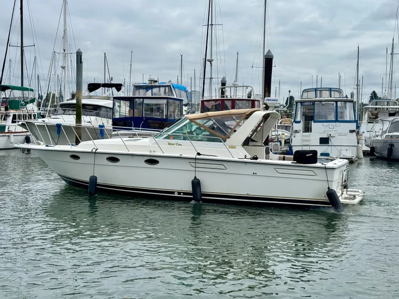 Slide: The Image of 1988 Tiara Yachts 3100 Open docked in a marina with other boats. - 31