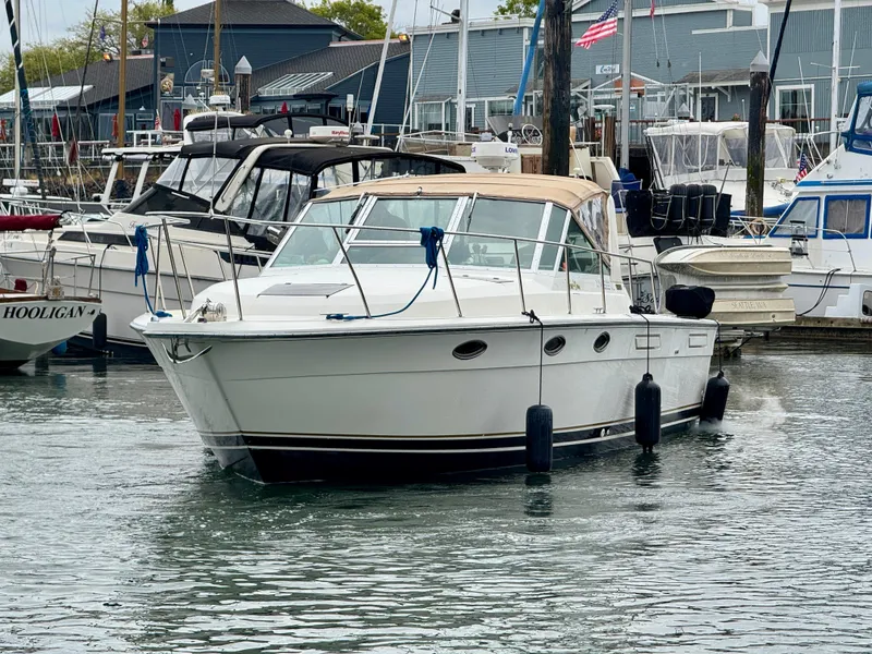 Slide: The Image of 1988 Tiara Yachts 3100 Open boat docked in a marina, surrounded by other vessels. - 34