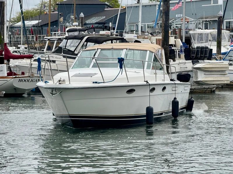 Slide: The Image of 1988 Tiara Yachts 3100 Open docked in a marina, surrounded by other boats. - 35