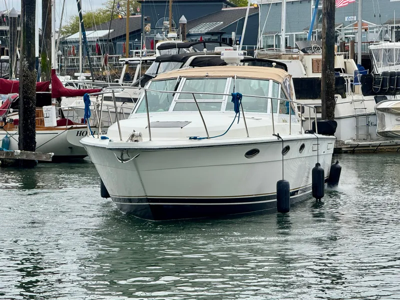 Slide: The Image of 1988 Tiara Yachts 3100 Open docked in a marina, surrounded by other boats. - 36