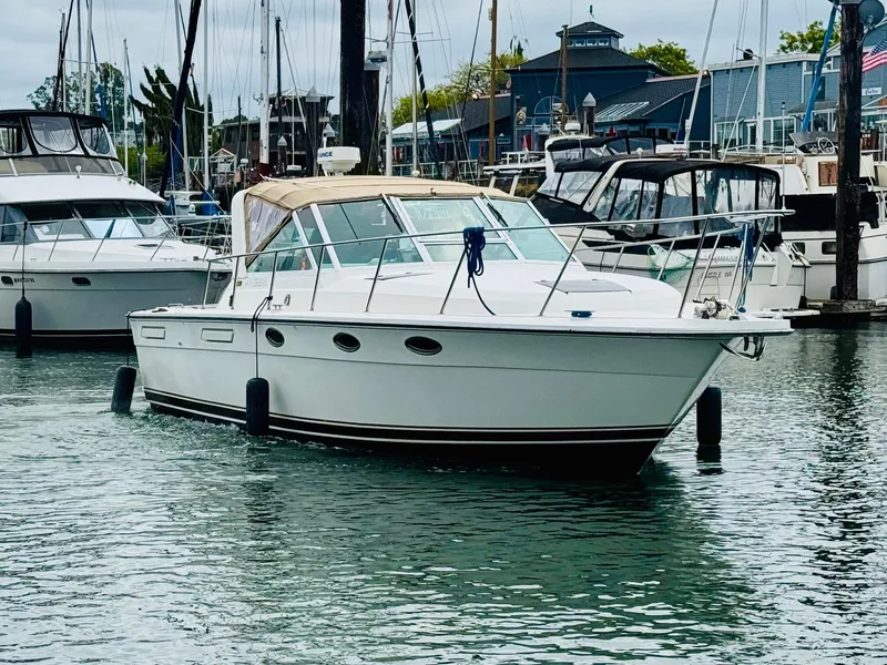 Slide: The Image of 1988 Tiara Yachts 3100 Open docked in a marina, surrounded by other boats. - 38