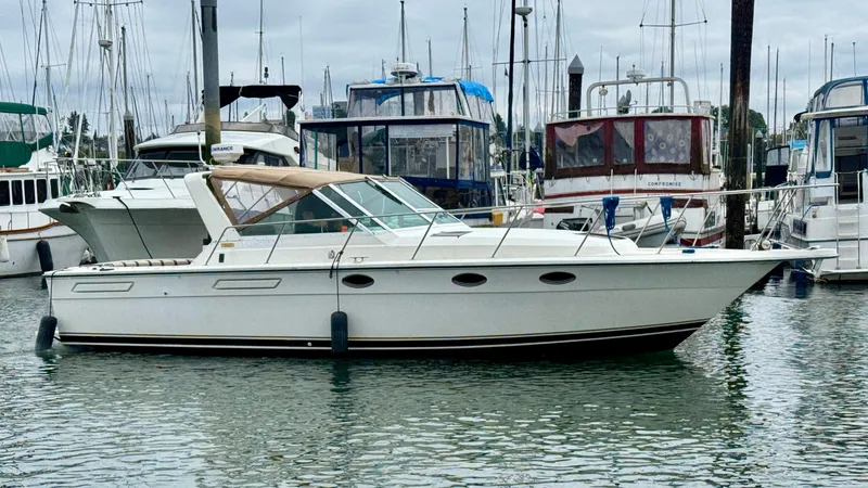 Slide: The Image of 1988 Tiara Yachts 3100 Open boat docked in a marina with sailboats. - 42