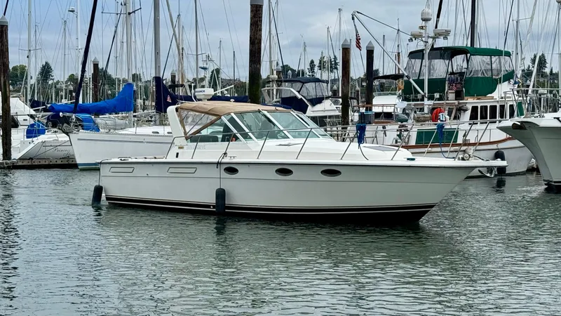 Slide: The Image of 1988 Tiara Yachts 3100 Open docked in a marina, surrounded by other boats. - 43