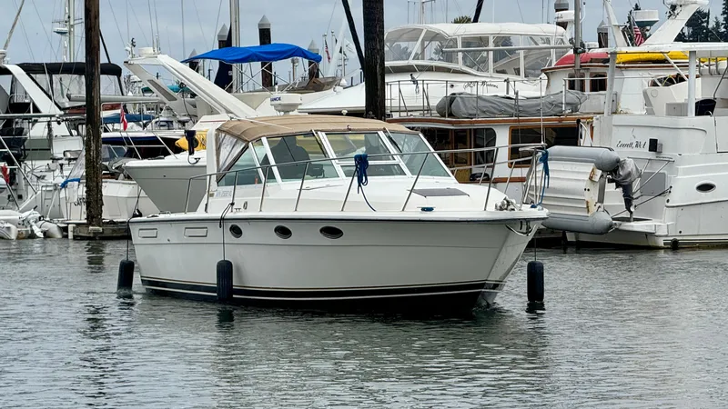 Slide: The Image of 1988 Tiara Yachts 3100 Open boat docked in a marina with sailboats. - 45