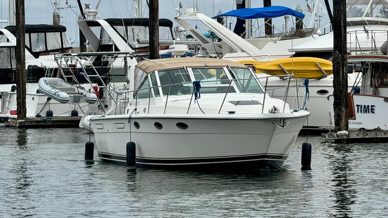 Slide: The Image of 1988 Tiara Yachts 3100 Open docked in a marina, surrounded by other boats. - 46