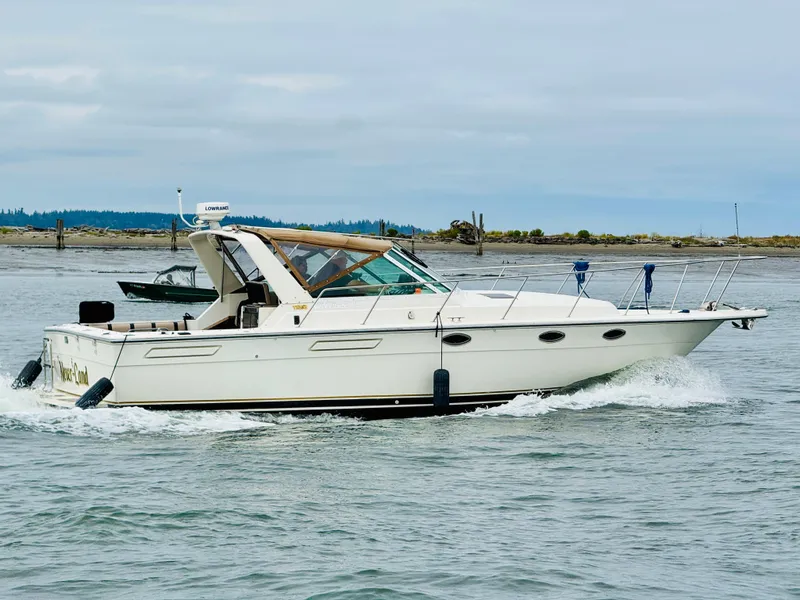 Slide: The Image of 1988 Tiara Yachts 3100 Open cruising on water near shoreline. - 49
