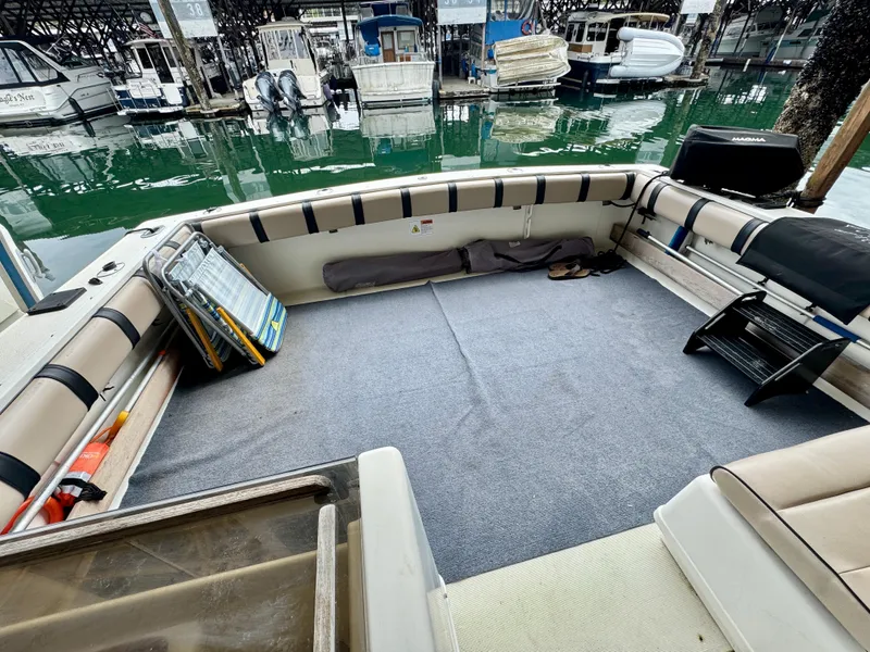 Slide: The Image of 1988 Tiara Yachts 3100 Open interior with seating and marina view. - 6