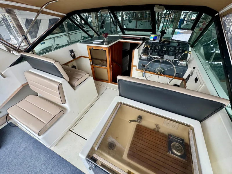 Slide: The Image of 1988 Tiara Yachts 3100 Open boat interior with seating and docked marina view. - 7