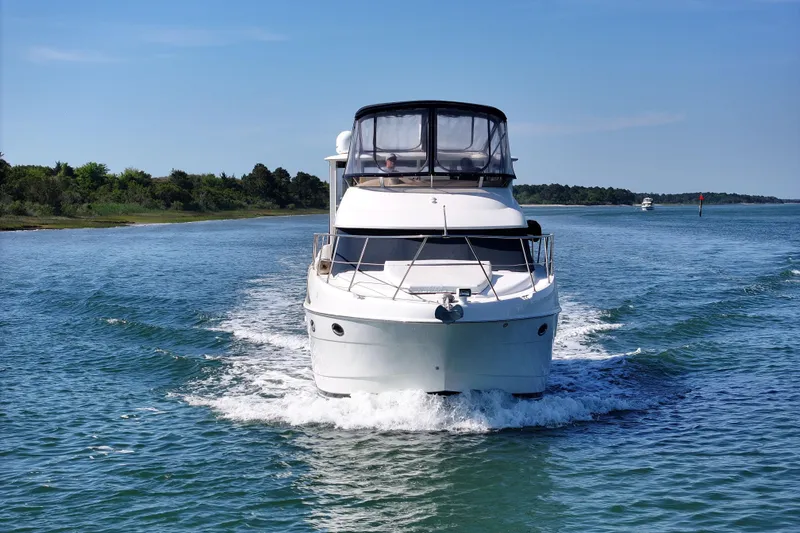 Slide: The Image of 2005 Meridian 368 Motoryacht cruising on a serene waterway under clear skies. - 14