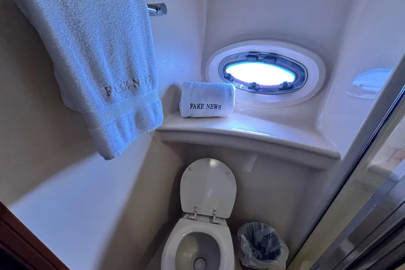 Slide: The Image of Bathroom in 2005 Meridian 368 Motoryacht with humorous "Fake News" towels. - 24
