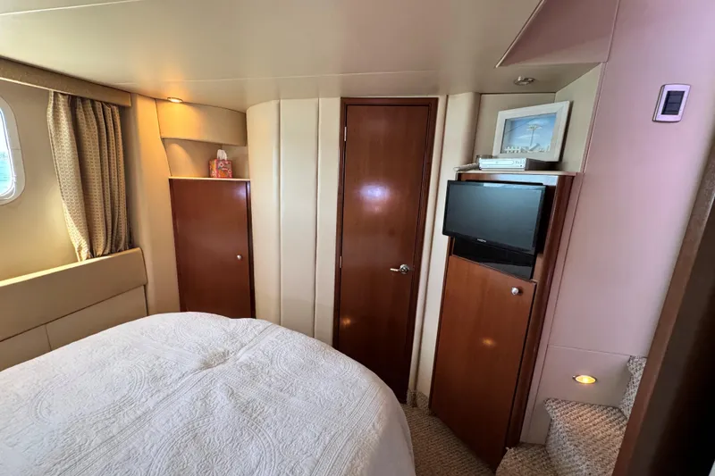 Slide: The Image of 2005 Meridian 368 Motoryacht bedroom with TV, wooden cabinets, and cozy decor. - 29