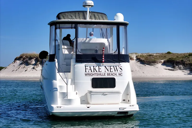 Slide: The Image of 2005 Meridian 368 Motoryacht on water near sandy beach, clear blue sky. - 3