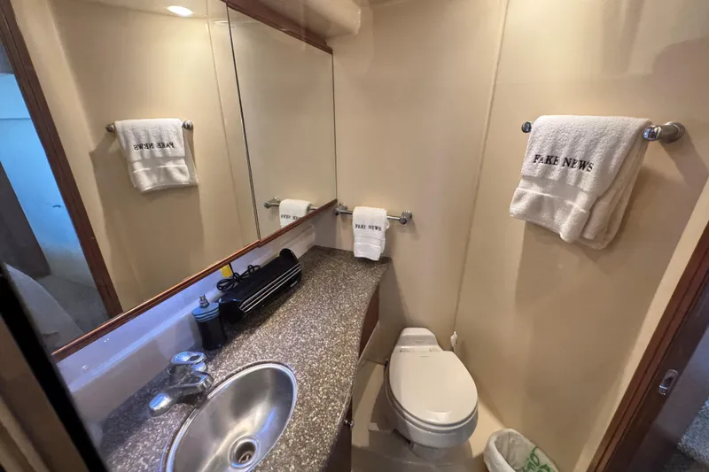 Slide: The Image of Bathroom of 2005 Meridian 368 Motoryacht with sink, toilet, and "FAKE NEWS" towels. - 34