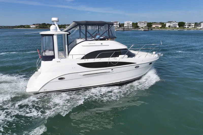 Slide: The Image of 2005 Meridian 368 Motoryacht cruising on a sunny day near coastal homes. - 9