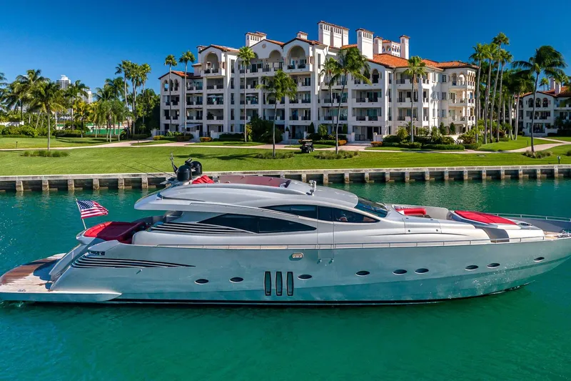 Slide: The Image of Luxury 2008 Pershing 90 yacht docked near waterfront residences, surrounded by palm trees. - 2