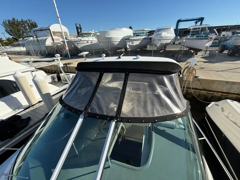 Slide: The Image of 2005 Cruisers Yachts 340 Express docked at marina, clear canopy visible. - 15