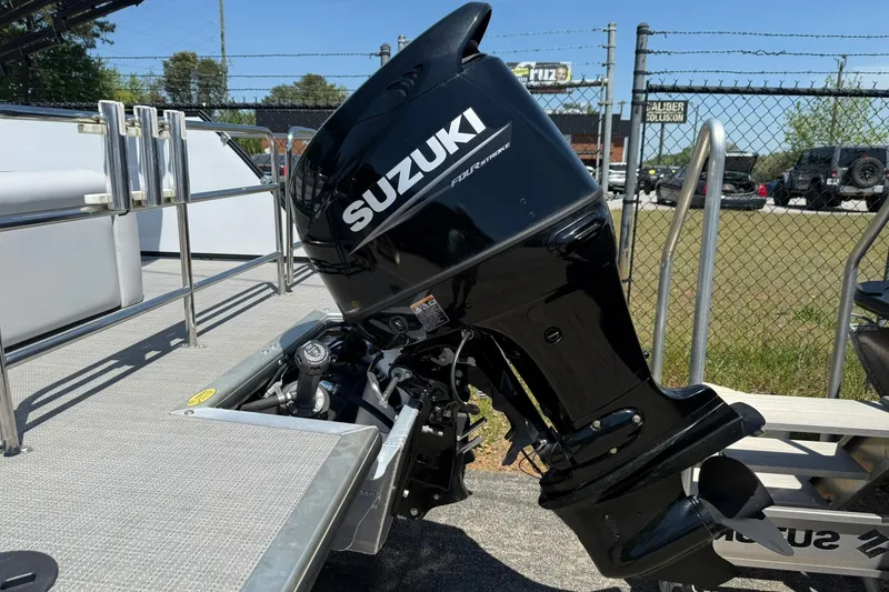 Slide: The Image of 2023 Bentley Pontoons 220 SWINGBACK with Suzuki outboard motor, parked outdoors. - 12