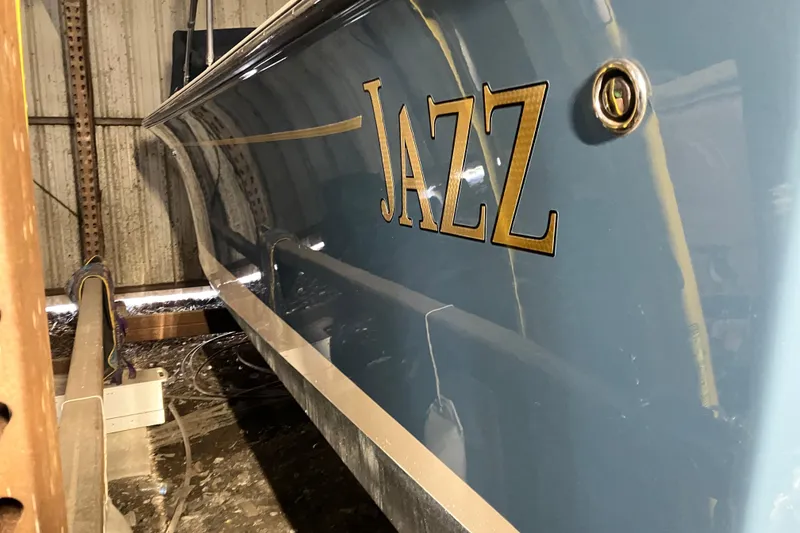 Slide: The Image of 2018 Rossiter 23 Classic Day Boat named "Jazz" in storage, showcasing sleek blue hull. - 7