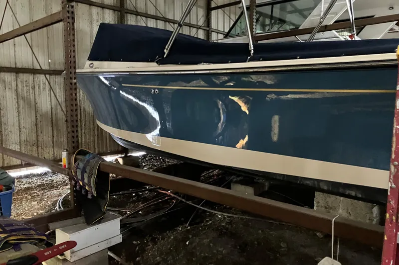 Slide: The Image of 2018 Rossiter 23 Classic Day Boat in storage, featuring a sleek blue hull. - 6