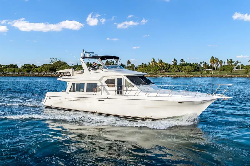 Slide: The Image of 2003 Navigator Rival 5700 yacht cruising on blue water under a clear sky. - 0
