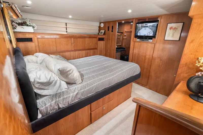 Slide: The Image of Luxurious bedroom interior of 2003 Navigator Rival 5700 yacht with wood paneling and TV. - 44