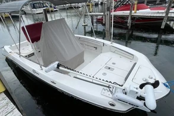 Slide: The Image of 2016 Yamaha Boats 190 FSH Deluxe docked, featuring a sleek white design and covered seating area. - 2