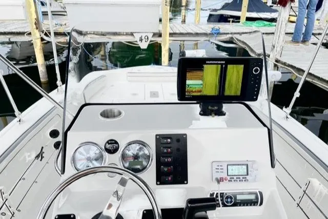 Slide: The Image of 2016 Yamaha Boats 190 FSH Deluxe dashboard with navigation equipment at a marina. - 4