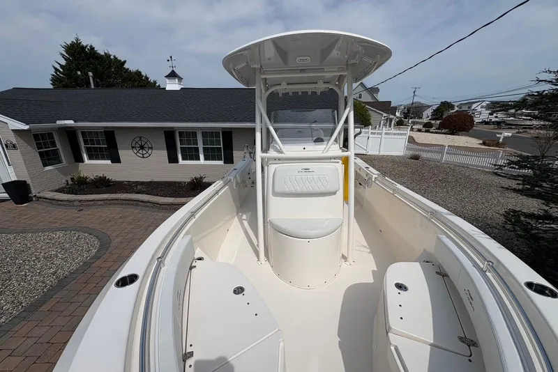 Slide: The Image of 2022 Cobia 220 Center Console boat parked in a residential driveway. - 12