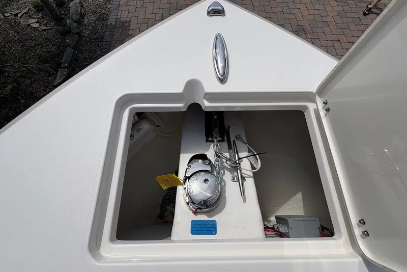 Slide: The Image of 2022 Cobia 220 Center Console boat anchor storage compartment open on deck. - 13