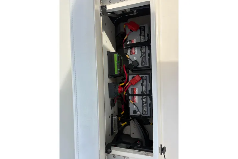 Slide: The Image of Battery compartment of a 2022 Cobia 220 Center Console boat, showing wiring and connections. - 19
